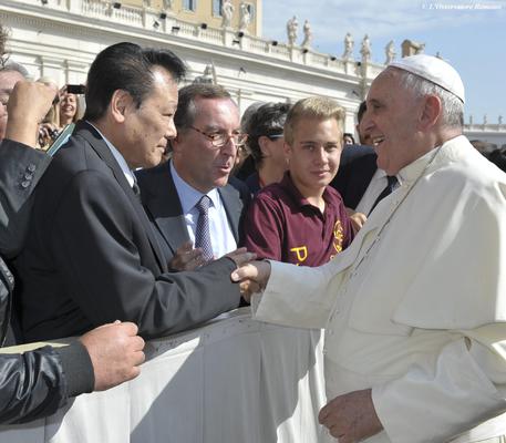 In this Oct. 1, 2014 photo, Pope Francis shakes hands with Japanese brain cancer specialist, Dr. Takanori Fukushima on the occasion of a pope's general audience in St. Peter's Square, at the Vatican. The Vatican on Wednesday, Oct. 21, 2015 denied Pope Francis is in ill health, saying his head is "absolutely perfect" after an Italian newspaper reported he has a small, curable brain tumor. The Japanese brain cancer specialist identified in the report as having made the diagnosis denied having ever examined the pontiff. In a statement issued late Wednesday by Duke University in North Carolina, Fukushima said: "I have never medically examined the pope. These stories are completely false." (L'Osservatore Romano/Pool via AP)
